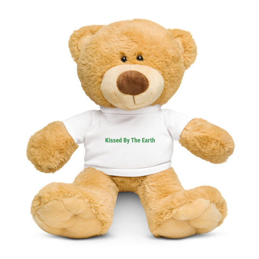 Teddy bear wearing a white shirt with 'Kissed By The Earth' text in green 